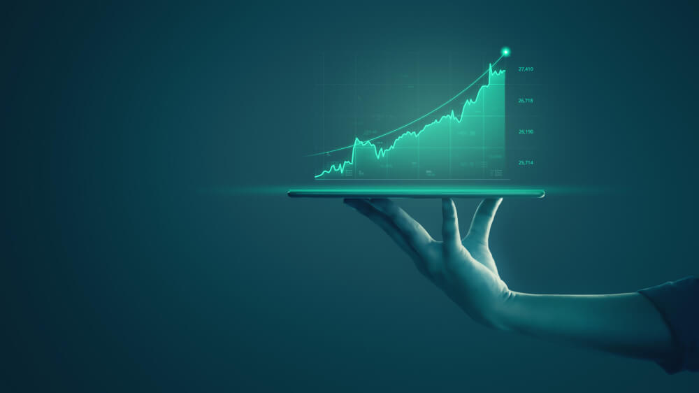 businessman-holding-tablet-showing-holographic-graphs-stock-market-statistics-gain-profits